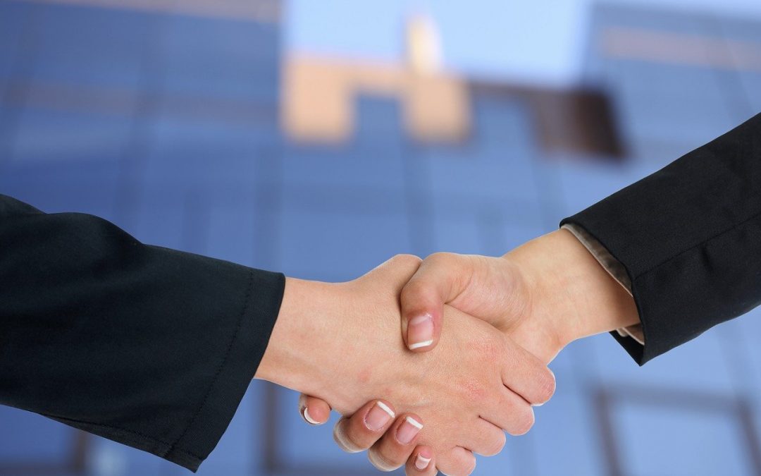 Two businesspeople shake hands in an office